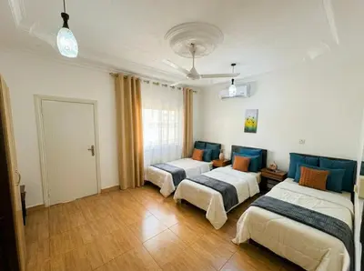 a room with three beds in a room at White Apartment in Aqaba