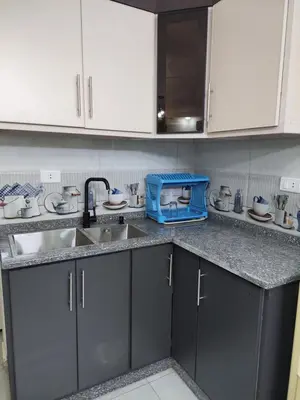 a kitchen counter with a sink and a blue toaster at New zarqa in Az Zarqa