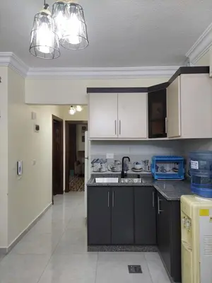 a kitchen with black and white cabinets and appliances at New zarqa in Az Zarqa