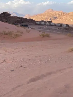a view of a desert with houses in the distance at Green Desert in Wadi Rum