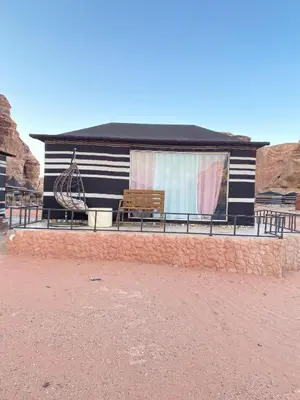 a black and white house with a bench and a window at Green Desert in Wadi Rum