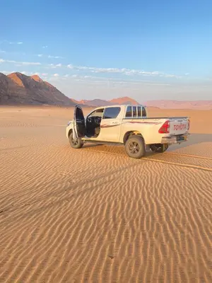 a white truck is parked in the desert at Green Desert in Wadi Rum