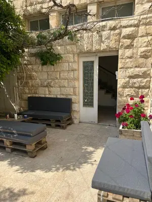 a stone building with a bench and a door at Locations Amman Palm Tree 4 in Ash Shumaysānī