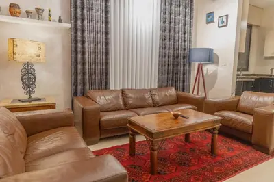 a living room with leather couches and a coffee table at High-end Apartment 2BDR in The most lively AMMAN شقة فاخرة في الدوار السابع in Amman