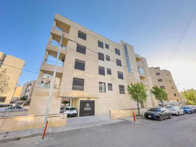 a large building with cars parked in front of it at High-end Apartment 2BDR in The most lively AMMAN شقة فاخرة في الدوار السابع in Amman