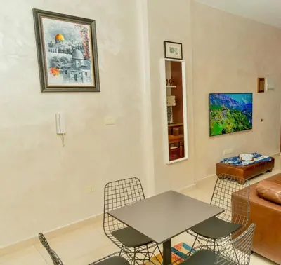a living room with a table and chairs and a couch at High-end Apartment 2BDR in The most lively AMMAN شقة فاخرة في الدوار السابع in Amman