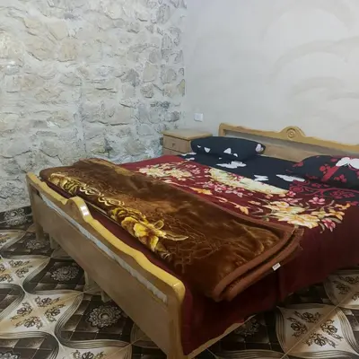 a bed with a brown blanket on top of it at Dana Moon hostel in Dana