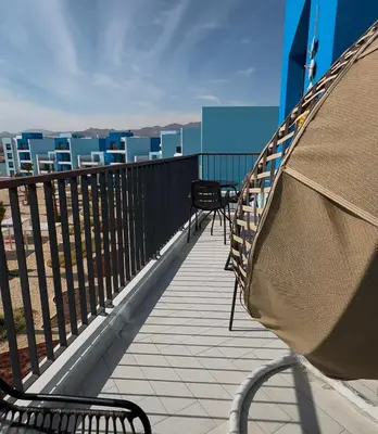 two chairs on a balcony with a view of the city at Azure haven Ayla Sea view Apartment in Aqaba