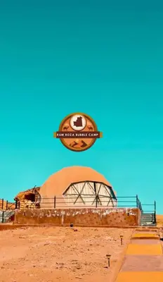 a building in the desert with a sign on it at RUM ROZA BUBBLES lUXURY CAMP in Wadi Rum