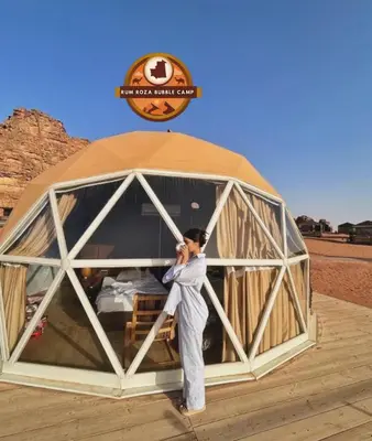 a woman is standing inside of a tent at RUM ROZA BUBBLES lUXURY CAMP in Wadi Rum
