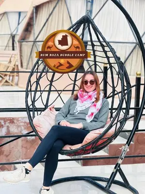 a woman sitting in a spiderweb swing at RUM ROZA BUBBLES lUXURY CAMP in Wadi Rum