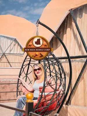 a woman sitting in a spiderweb ride at a roller coaster at RUM ROZA BUBBLES lUXURY CAMP in Wadi Rum