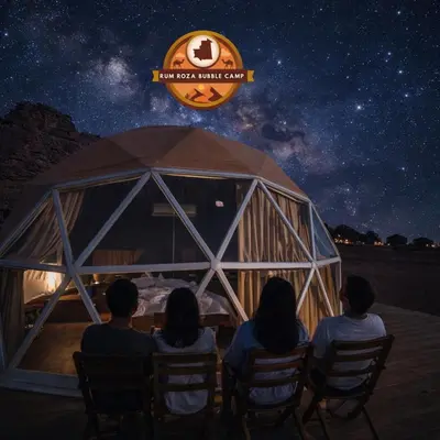 a group of people sitting around a table under a starry sky at RUM ROZA BUBBLES lUXURY CAMP in Wadi Rum