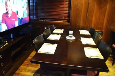 a dining room with a table and a television at فندق أميري سويت in Umm Uthainah
