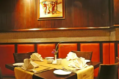 a table in a restaurant with a yellow table cloth at فندق أميري سويت in Umm Uthainah