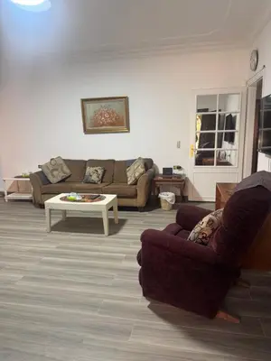 a living room with two couches and a coffee table at Abdoun apartment with a garden in Amman