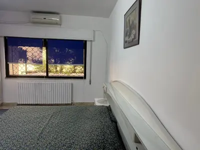 a white room with a bed and a window at Abdoun apartment with a garden in Amman