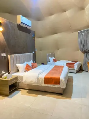 a bedroom with two beds and a tv on the wall at Wadi Rum famous luxury camp in Wadi Rum
