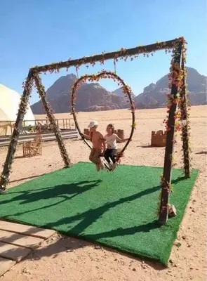 two people playing on a swing in the desert at Sami Rum Mountains in Wadi Rum