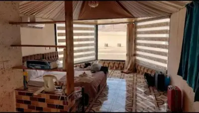 a bedroom with a bed and a large window at Sami Rum Mountains in Wadi Rum
