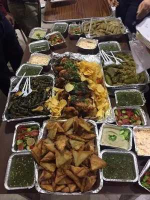 a table with many trays of different types of food at Daban Inn in Dhībān