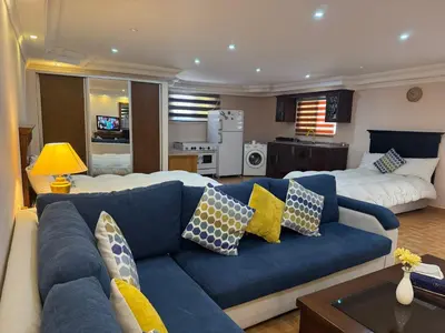 a living room with a blue couch with pillows at Petra EcoStay in Wadi Musa