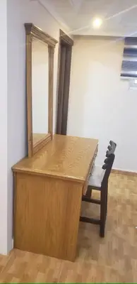 a wooden desk with a mirror and a chair at Petra EcoStay in Wadi Musa