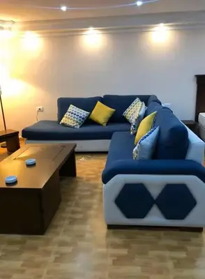 a living room with a blue couch and a coffee table at Petra EcoStay in Wadi Musa
