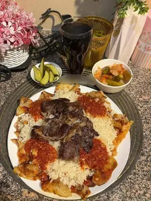a plate of food with meat and rice on a table at الطل هاوس in Ar Rashādīyah