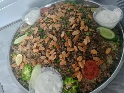 a plate of food with nuts and vegetables and sauce at الطل هاوس in Ar Rashādīyah
