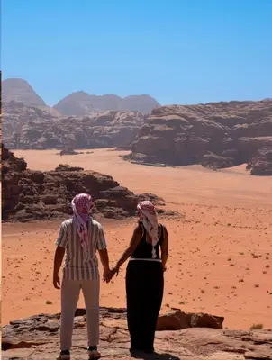 a man and a woman standing in the desert at RUM DESERT BREEZE lUXURY CAMP&JEEP TOUR in Wadi Rum