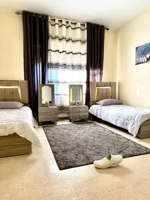 a bedroom with two beds and a large window at Stylish 3 Bedroom apartment in Amman in Amman