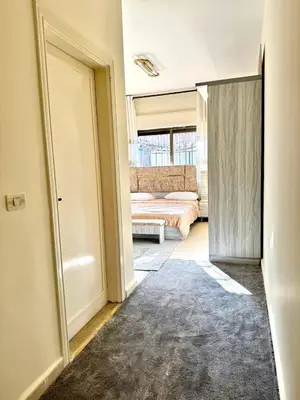 a hallway with a room with a bed and a door at Stylish 3 Bedroom apartment in Amman in Amman