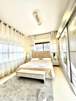 a bedroom with a bed and a large window at Stylish 3 Bedroom apartment in Amman in Amman
