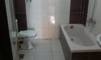 a bathroom with a toilet and a bath tub at بيت راس هوستل in Bayt Raʼs