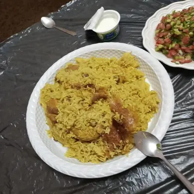 a plate of rice and a spoon on a table at بيت راس هوستل in Bayt Raʼs