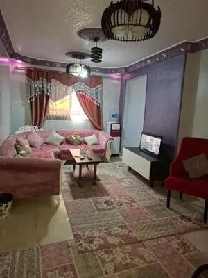 a living room with a couch and a table at بيت راس هوستل in Bayt Raʼs