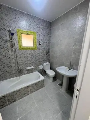 a bathroom with a tub and a toilet and a sink at بيت راس هوستل in Bayt Raʼs