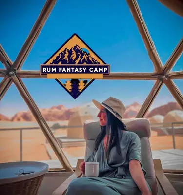 a woman sitting in a chair with a cup of coffee at RUM FANTAS BUBBLE lUXURY CAMP in Wadi Rum