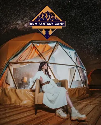 a woman sitting in a chair in front of a tent at RUM FANTAS BUBBLE lUXURY CAMP in Wadi Rum