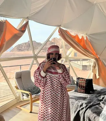 a girl taking a picture of a tent at RUM FANTAS BUBBLE lUXURY CAMP in Wadi Rum