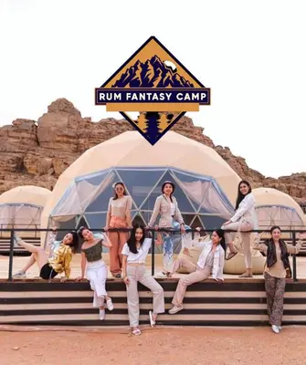 a group of women sitting on steps in front of a tent at RUM FANTAS BUBBLE lUXURY CAMP in Wadi Rum