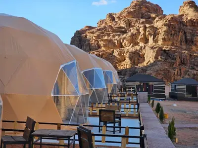 a row of tables and chairs in front of a mountain at Lowrance luxury camp in Wadi Rum