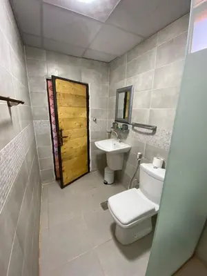 a bathroom with a toilet and a sink and a door at Lowrance luxury camp in Wadi Rum