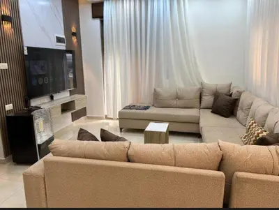 a living room with two couches and a flat screen tv at شقه مفروشة ذات اطلالة جميلة ومكان هادئ in Irbid