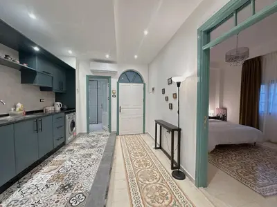 a bedroom with a bed and a kitchen with a door at Old Town Charming Two-Bedroom Flat in Amman