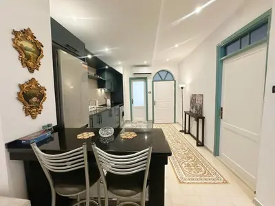 a kitchen with a table and chairs in a room at Old Town Charming Two-Bedroom Flat in Amman