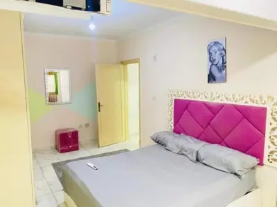 a bedroom with a large bed with a pink headboard at اذرح فارم in Udhruḩ