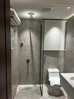 a bathroom with a shower with a toilet and a sink at ساكب هاوس in Sākib