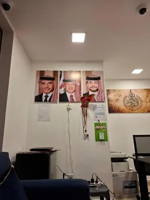 a room with pictures of presidents on the wall at مراسيم للشقق الفندقية in Amman